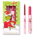 Berry Grinchy So Juicy Plumping Gloss Stick by ColourPop shown with matching lip liner, both in pink tubes, set beside a green ColourPop x The Grinch holiday box featuring the Grinch; berry shade bullet and liner tip visible.