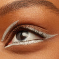 Metallic silver graphic wing and floating crease accent a brown eye, showcasing ColourPop Crème Gel Liner in Total Essentials, applied along upper and lower lash lines and inner corner for a sharp, chrome finish in a close-up beauty shot.