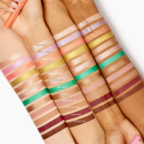 Surf Sesh ColourPop Shadow Stix swatched as a bold metallic teal on four arms of different skin tones, displayed among labeled shade swatches, with a hand holding a creamy ColourPop Shadow Stix for scale.
