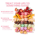 Orange Vanilla Lip Mask jar anchors a vertical stack of pastel lip mask pots, surrounded by fresh strawberries, orange wedges, vanilla bean, cake, chocolate chunks, pistachio gelato, and jelly donut bites, highlighting the ColourPop Lip Care Kit in a bright flat lay.