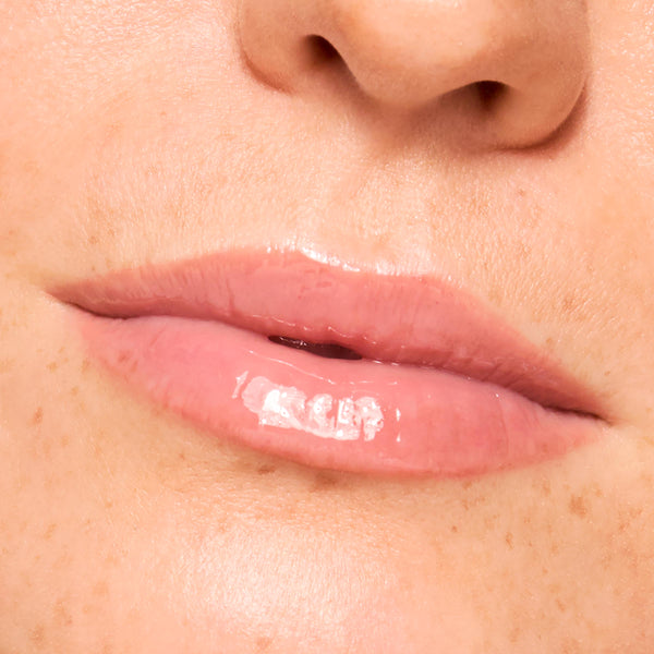 Close-up lips wearing a sheer baby pink, high-shine finish from Pretty in Pastels, a ColourPop Glossy Lip Balm Trio, showing hydrated, smooth texture and glassy sheen against natural skin in studio lighting.