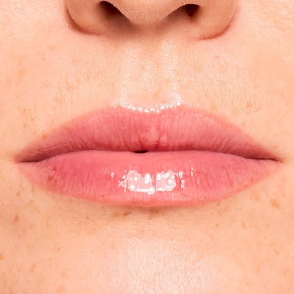 Glossy lips wearing Get Rich ColourPop Glossy Lip Balm Trio, showing a sheer berry‑pink tint and high-shine, hydrated finish in a tight macro close-up of the mouth and surrounding skin.
