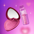 Heart to Get Sorry Not Sorry blush + UGL set showing a shimmery pink heart-shaped blush compact with mirror beside a glossy pink lip product with heart-shaped cap, floating against a glowing purple-pink background with soft sparkles.