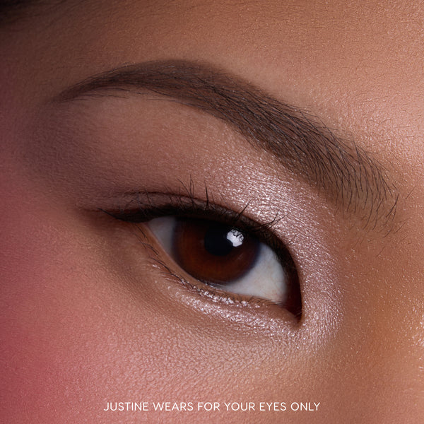 Close-up of a model’s brown eye wearing Heart to Get For Your Eyes Only Shadow Stix, showing soft metallic nude shimmer across the eyelid and lower lash line on smooth, natural skin, highlighting the creamy eyeshadow finish for US makeup shoppers.