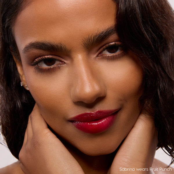Baby Fox lip stain adding glossy, deep cherry-red color to a model’s lips, showing a high-shine, lightweight finish in a tight beauty close-up; ColourPop Lip Stain highlights rich pigment and a smooth, hydrating look for everyday wear.