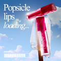 Tickle Me Pink ColourPop Lip Stain showcased inside a melting popsicle, droplets glistening as the hot-pink tube rests on a wooden stick against a sunny blue sky with clouds, suggesting a fresh, popsicle-lips, summer-ready look.