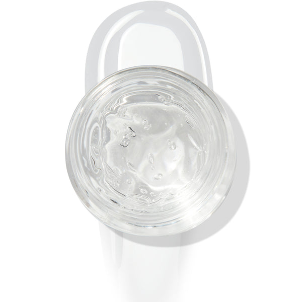 In The Clear Face & Eye Gloss in an open round jar gleams with a glossy swipe beneath it on a white background, showcasing the ColourPop Face & Eye Gloss for dewy, glass-skin shine on lids and cheeks.