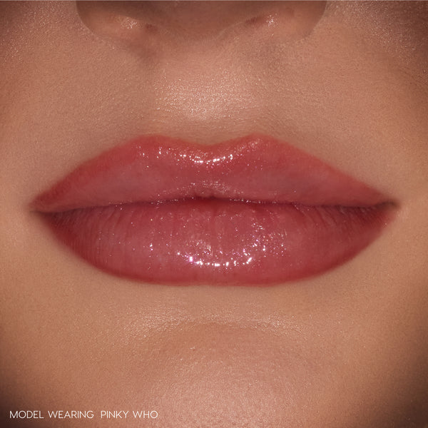 Glossy lips wearing ColourPop So Juicy Plumping Gloss Stick in Pinky Who, delivering sheer rosy pink shine that visibly plumps and smooths the mouth, shown in a tight close-up on natural skin as a beauty swatch.