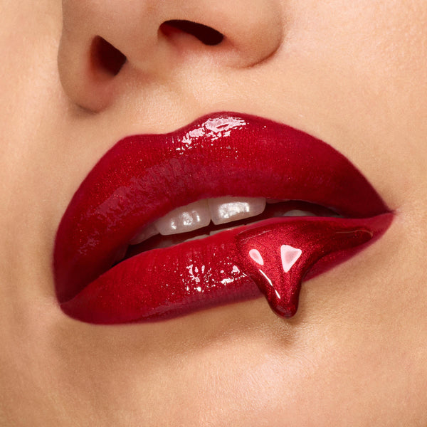 Glossy deep-red lips showcase high-shine lip gloss with a fang-shaped drip, spotlighting the Twilight New Moon x ColourPop Full Collection Set, a ColourPop Full Collection Set inspired by vampy glamour.