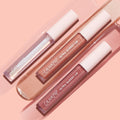 Three ColourPop Ultra Glossy Lip tubes - Perfect 4 U Ultra Glossy Lip bundle - rest diagonally on a peach backdrop, with glossy swatches showing clear sparkle, golden nude shimmer, and rosy pink finishes.