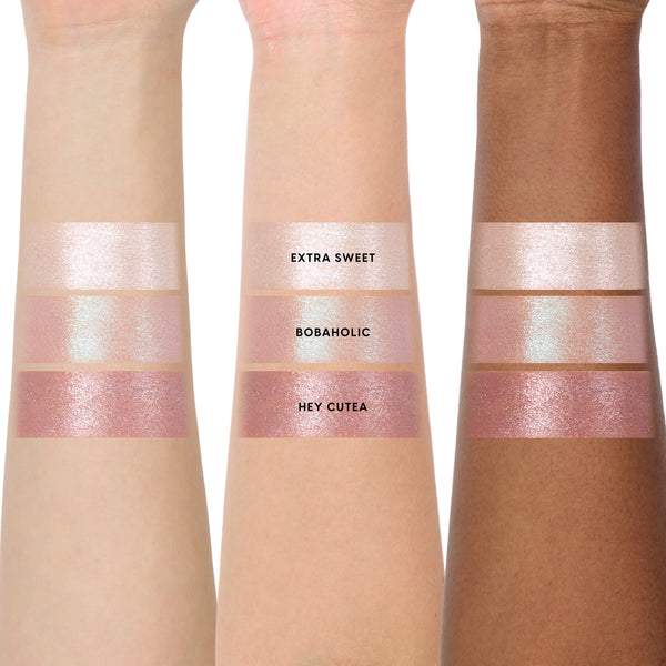 Three arms in different skin tones display the Sweet Sips full collection set of Super Shock Shadow swatches, showing shimmery shades Extra Sweet, Bobaholic, and Hey Cutea in metallic pink and champagne hues for comparison across skin tones.