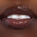 Glistening lips wear Gumdrop Buttons, a rich cocoa-brown ColourPop Candy Lip Oil, showing high-shine, smooth hydration and semi-sheer pigment in a close-up beauty swatch.