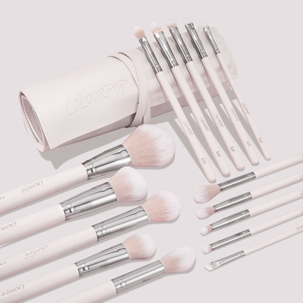 Metallic Mood ColourPop Shadow Palette & Brush Set displayed with a blush-pink brush roll; soft pink handles with silver ferrules and fluffy face plus precision eye brushes labeled E1–E8 are fanned on a light background, logo embossed on the roll.