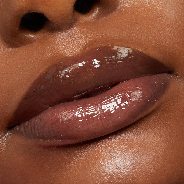 Glossy brown-plum lips coated in Vampy Lips Lux Lip Oil, catching light in an extreme close-up beauty shot that shows a glassy, smooth finish - an accurate ColourPop Lux Lip Oil swatch for US shoppers.