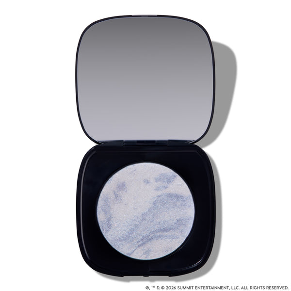 Open compact of Change Me Mega Highlighter with shimmering icy lavender and silver marbled pan set in a sleek black case with mirror, styled on a white background for the Twilight makeup collection.