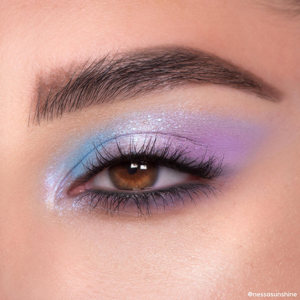 Pastel blue and lavender shimmer eyeshadow blends across a brown eye, showcasing the In A Trance ColourPop Shadow Palette with iridescent sparkle, tight-lined lashes, and a soft gradient finish in a close-up beauty look.