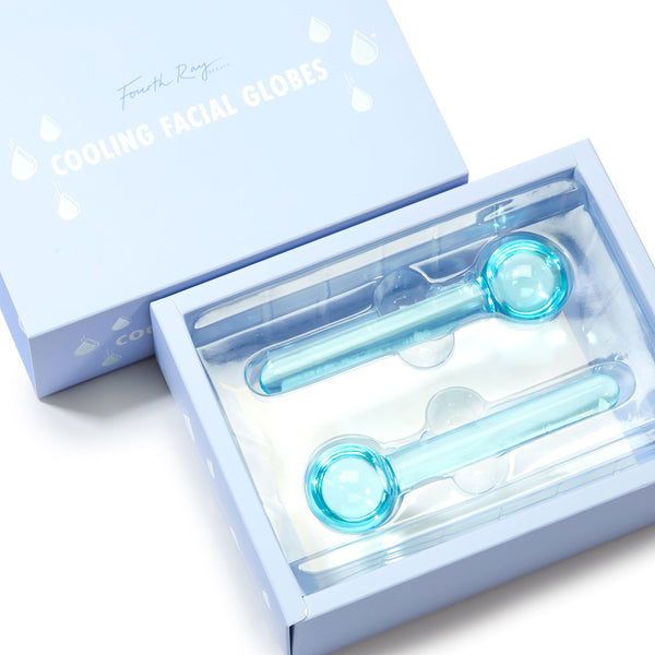 Two blue glass Cooling Facial Globes rest in an open light-blue box labeled Cooling Facial Globes, showing long handles and round massage heads for de-puffing and soothing; ColourPop Skincare Tools And Accessories for home facials.