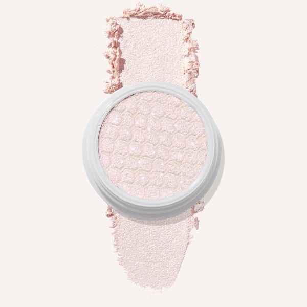 Colourpop Mountain Lion Super Shock Shadow single pan with a shimmery pale pink shade, showing its textured metallic finish and a soft swatch of the powder on a light background for detailed eyeshadow color payoff view.