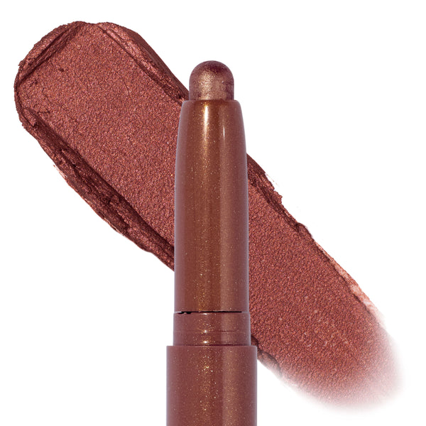 So Into U ColourPop Shadow Stix displays a twist-up eyeshadow crayon in shimmering rose-bronze, tip extended with a wide metallic swatch swept behind on a clean white background.