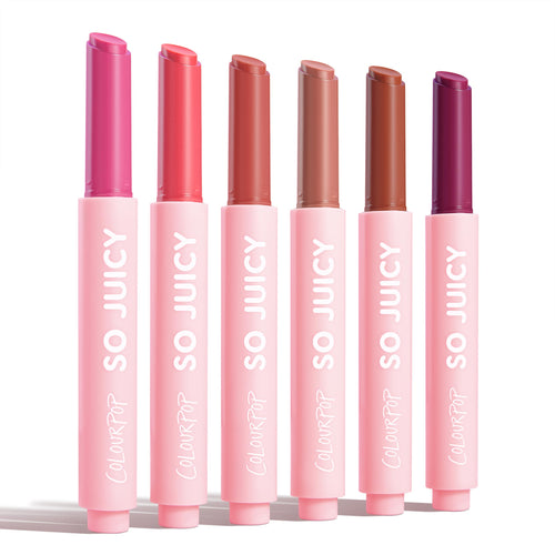 Six ColourPop So Juicy Plumping Gloss Balm with Peptides sticks, So Balm, stand upright and uncapped on a white background, displaying fuchsia, coral, rosy nude, beige, warm brown, and deep berry in pink tubes labeled SO JUICY.