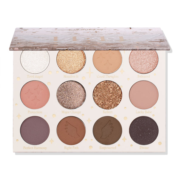 11:11 ColourPop Shadow Palette sits with lid half open, revealing 12 neutral shades - mattes and glittery metallics in ivory, gold, rose, taupe, warm browns, plum, and deep charcoal - with star/wing embossing and shade names on a white background.