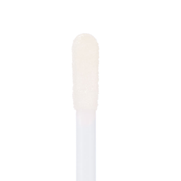 Soft doe-foot applicator coated in 20 Carats Ultra Glossy Lip glides on clear, micro-shimmer shine, captured in macro on a white background to show the plush tip and wet look - ColourPop Ultra Glossy Lip.
