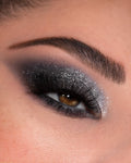 Smoky charcoal-to-silver glitter eyeshadow blended across a brown eye with dramatic lashes and defined brow, created with the Rock Candy ColourPop Shadow Palette, highlighting metallic shimmer and deep matte tones for a bold night-out look.