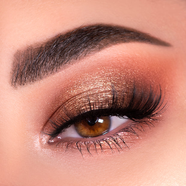 Shimmering copper-bronze eye shadow blends across a closed lid with fluttery lashes, showcasing warm nude tones created with the Nude Mood ColourPop Shadow Palette, featuring a soft matte crease and glowing inner corner highlight.