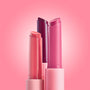 Three She’s So Juicy gloss balm sticks stand uncapped, showing coral, berry, and rosy pink bullets against a soft pink gradient, highlighting the ColourPop So Juicy Plumping Gloss Balm with Peptides for shiny, fuller-looking lips.
