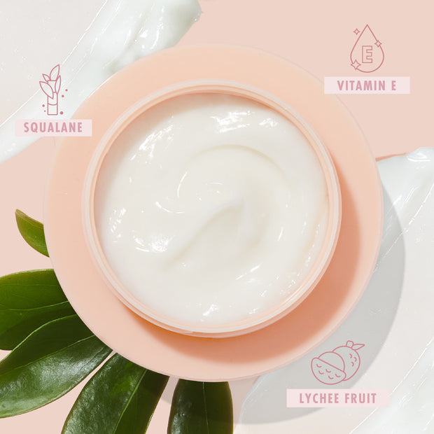 Peach jar of The Daily Face Cream opens to a glossy swirl, a hydrating ColourPop Face Moisturizer, set on a pale pink background with green leaves, cream smears, and ingredient icons for squalane, vitamin E, and lychee fruit.
