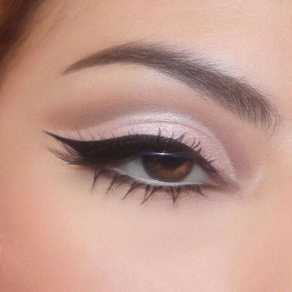 Shimmery cool taupe eyeshadow and a soft matte crease blend into a sharp black winged liner on a brown eye, showcasing The Ultimate Stunner ColourPop Shadow Palette & Brush Set with blendable neutrals and precise brush strokes for everyday glam.