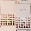 Bold + Bare ColourPop Shadow Palette Set displaying two open 30-pan palettes - warm neutrals and coppers on the left, cool taupes, mauves, and charcoals on the right - with matte and shimmer finishes, on a beige background with branded sleeves.