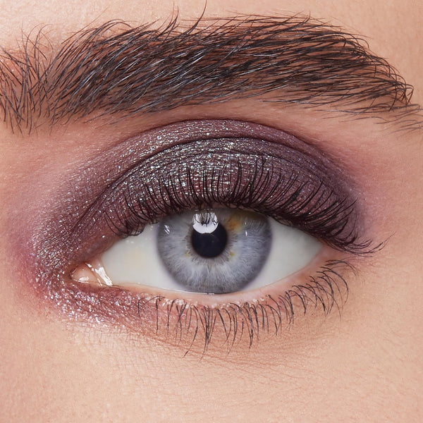 Shimmery plum eyeshadow sweeps across the eyelid, showcasing ColourPop Bae Super Shock Shadow on a close-up eye with defined lashes and brow, highlighting metallic sparkle, smooth blend, and rich payoff for a bold evening makeup look.