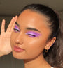 Violet gradient eye makeup created with the Fade Into Hue ColourPop Shadow Palette, model winks as rhinestones trace the lids in natural sunlight, showcasing the blendable pigment and rainbow tones of this shadow palette.