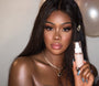 ColourPop SOL Shimmering Dry Oil in Soft Pink, clear rectangular bottle with white pump and SOL logo, held by a model with luminous skin to showcase the pearly pink shimmer; soft studio lighting and a neutral backdrop highlight body glow.