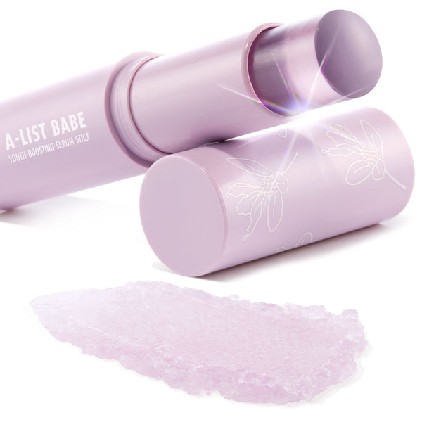 A-List Babe youth-boosting serum stick shines with the twist-up lavender balm extended, pastel lilac tube and cap with white floral line art beside it, and a soft lilac swatch on a clean white background; ColourPop Serum Stick.