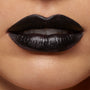 ColourPop Lippie Pencil in Bull Chic lines and fills lips in opaque true black with a soft satin sheen, shown in a tight beauty close-up displaying crisp edges and full coverage.