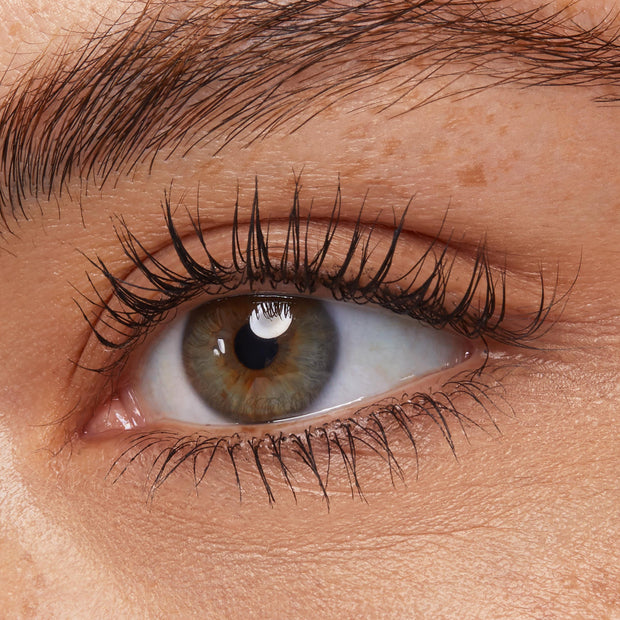 Defined upper and lower lashes coated with ColourPop Act Natural Mascara in Black, showing length, separation, and a natural, clump-free finish on a close-up hazel eye; subtle curl and lift ideal for everyday makeup.