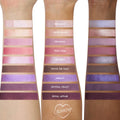 Arm swatches show the All Amethyst ColourPop Shadow Palette on three skin tones, displaying nine lilac, pink, and deep plum shades in matte and shimmer - e.g., Brilliant, Feb’s Gem, Royal Affair - with labeled stripes for color payoff comparison.