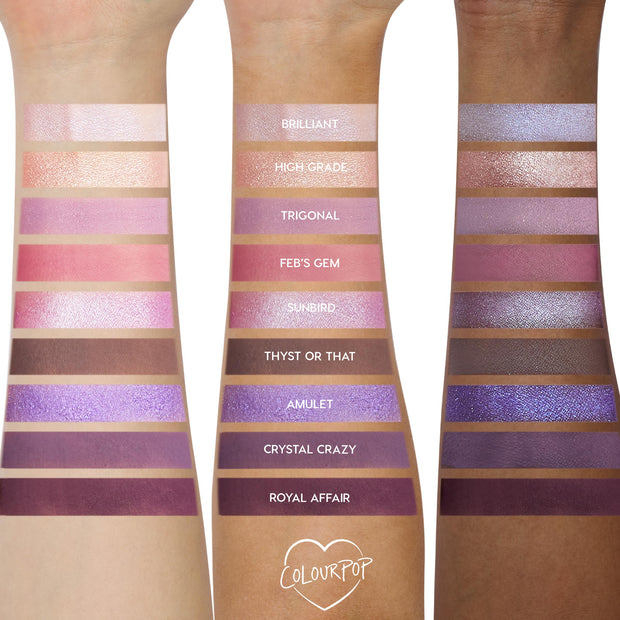 Arm swatches show the All Amethyst ColourPop Shadow Palette on three skin tones, displaying nine lilac, pink, and deep plum shades in matte and shimmer - e.g., Brilliant, Feb’s Gem, Royal Affair - with labeled stripes for color payoff comparison.