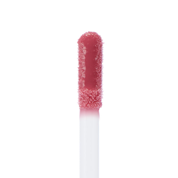Doe-foot applicator coated in the All Me shade of ColourPop Ultra Glossy Lip, a high-shine rosy pink gloss, shown in an extreme close-up on a white background.