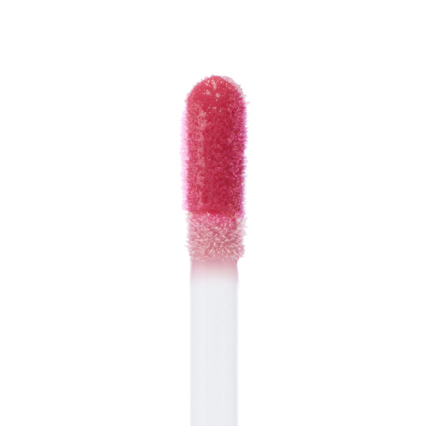 Doe-foot applicator swipes rosy pink Attention Plz Ultra Blotted Lip, showcasing creamy soft-focus pigment on a fuzzy wand against a clean white background; ColourPop Ultra Blotted Lip macro highlights the blotted, diffused finish.