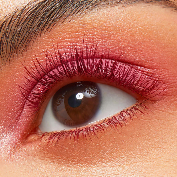 Upper and lower lashes coated in the Pink Inc. shade of ColourPop BFF Mascara, fanning around a brown eye with matching pink liner and soft shimmer, macro close-up showing bold length and definition.