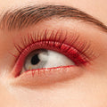 Red-coated eyelashes fan upward, wearing the Left on Red shade of the ColourPop BFF Mascara, in a tight close-up of an eye with clean skin and a groomed brow, emphasizing bold pigment and defined length.