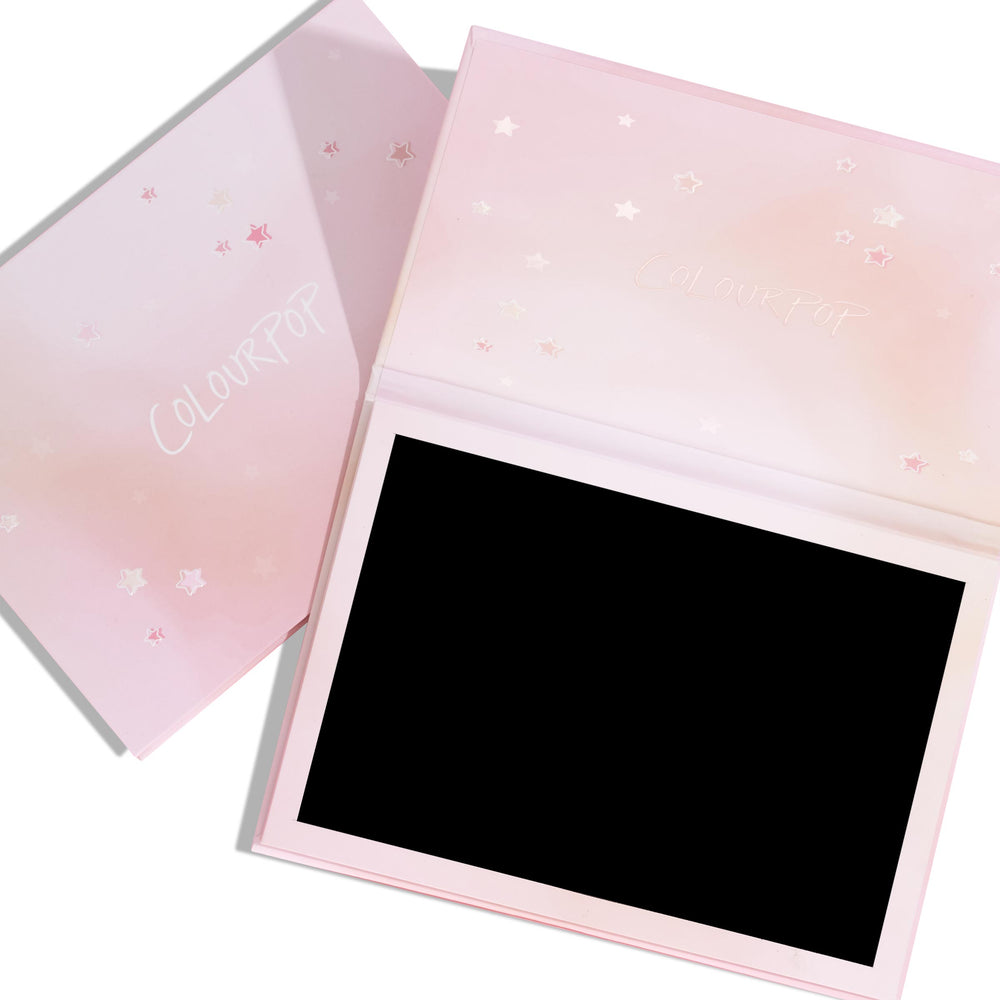 Stars Large Empty Palette lying open to show its black magnetic base, set atop its matching closed case with a pink ombré cover, scattered star details, and ColourPop logo; a large ColourPop Empty Palette for customizing eyeshadow pans.