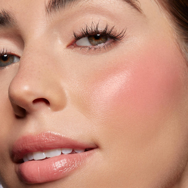 Baby Bunny, a ColourPop Lip and Cheek Balm, softens a model’s cheeks with a dewy rosy flush and adds sheer pink shine to lips; extreme close-up highlights smooth, hydrated skin, natural glow, and a buildable glossy finish.