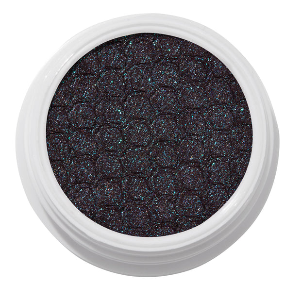 ColourPop Bae Super Shock Shadow shimmering in a white round pot, a deep plum-black cream eyeshadow packed with teal and blue microglitter and a quilted texture, shown close-up on a clean white background.