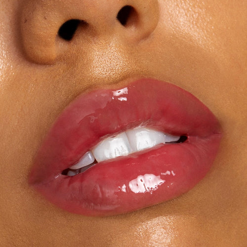 Glossy rosy-pink lips wearing Bengal Lux Lip Oil, catching light to show a high-shine, sheer tint and smooth finish in an extreme close-up beauty shot; ColourPop Lux Lip Oil.
