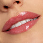 Lips wearing Bengal Lux Lip Oil deliver a sheer rosy pink tint with glassy shine, shown in a close-up beauty shot under soft lighting, highlighting the smooth finish of ColourPop Lux Lip Oil in the Bengal shade on natural lips.