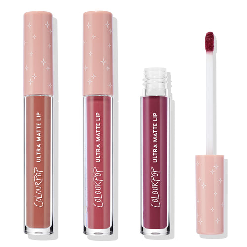Berry Pickin’ ColourPop Ultra Matte Lip liquid lipstick set standing in a row, three clear tubes with blush-pink star caps from nude to deep berry, one opened showing a doe-foot applicator on a clean white background.